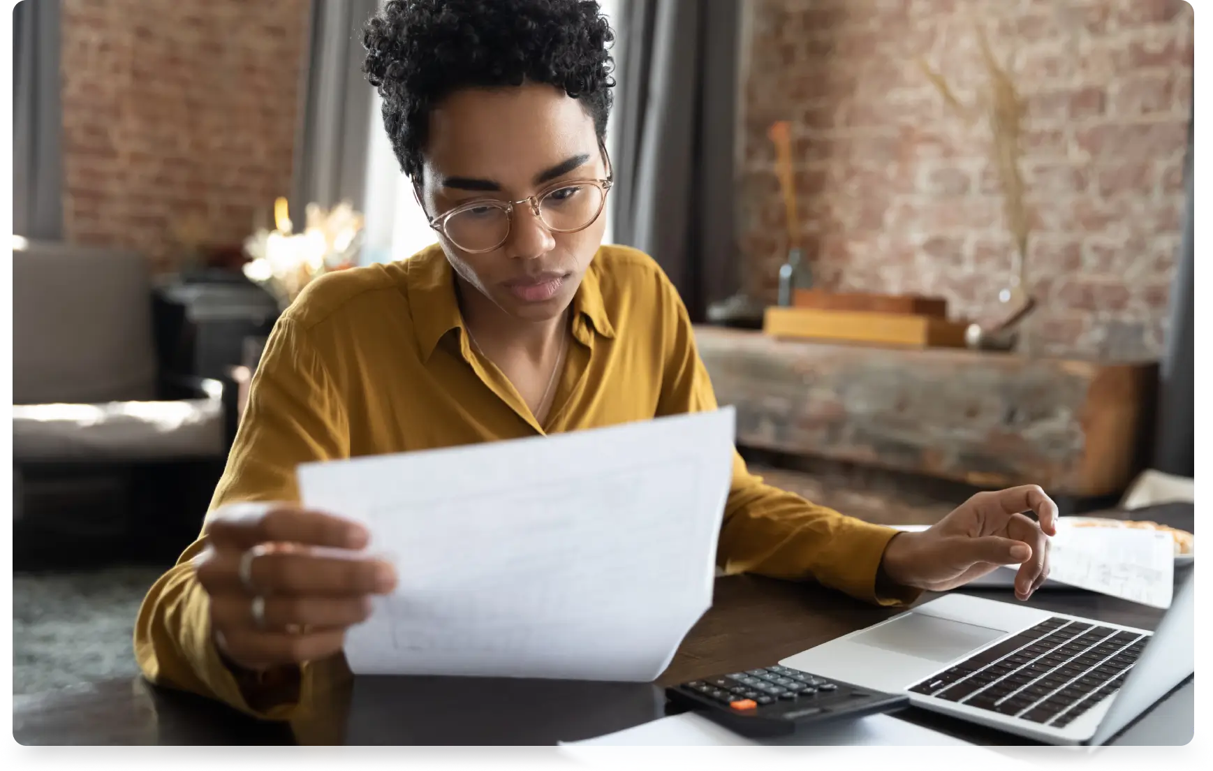 Woman reviewing paperwork at her desk.
