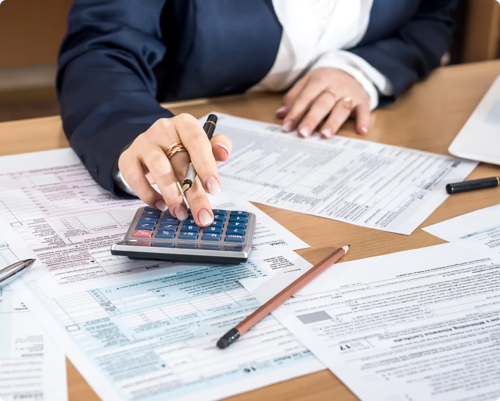 Woman calculating taxes with calculator.